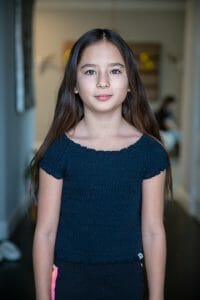 Kids blog post GIGI doorway-3 | Kelly Williams Photography brunette girl standing straight looking forward head and shoulders | How to get your child a modeling agent in Dallas, Texas 2025
