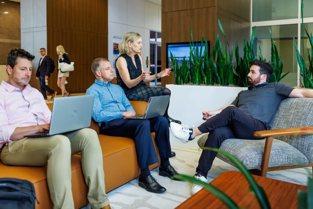 Casual business meeting with four executives in building lobby